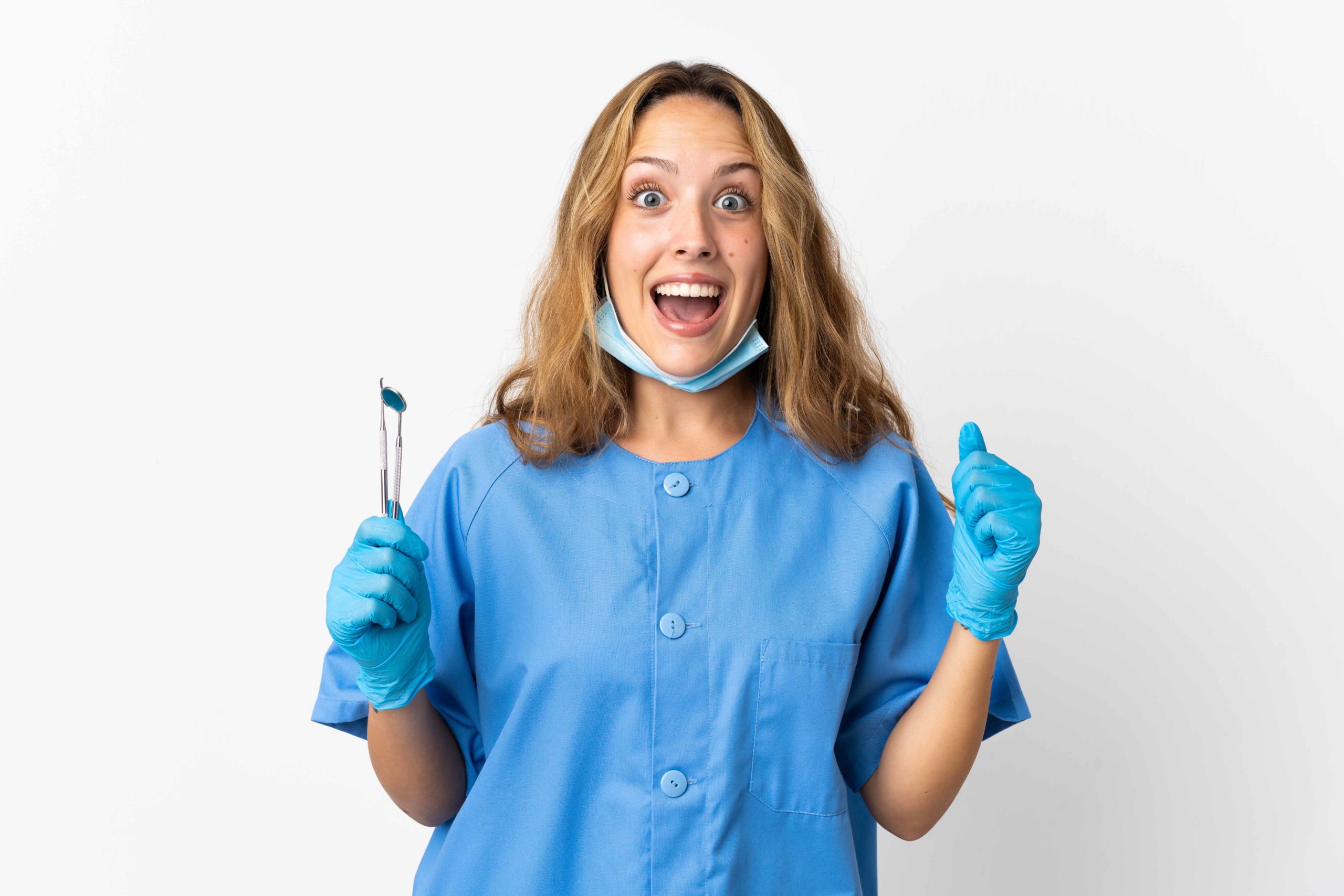 青い白衣を着た歯科衛生士が片手に治療木後を持っている