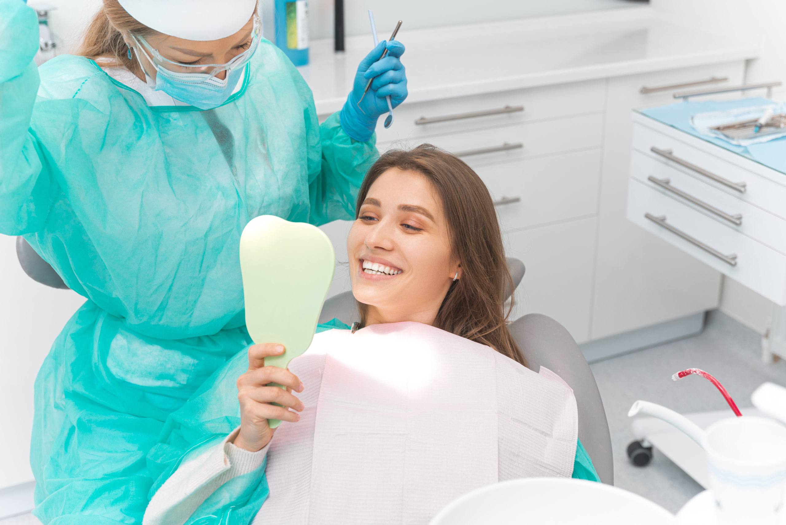 鏡で歯を確認する笑顔の患者と歯科医