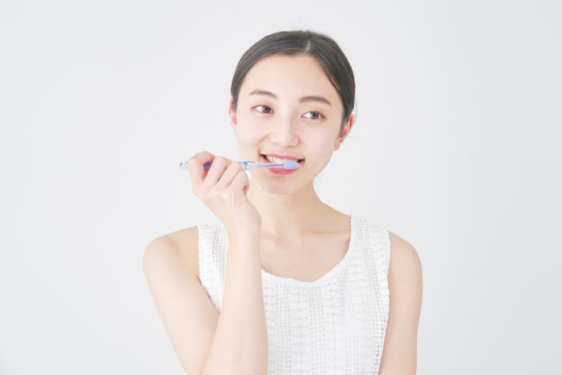 歯周病の予防で歯磨きする女性