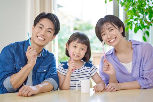 歯ブラシを手に持った家族のイメージ