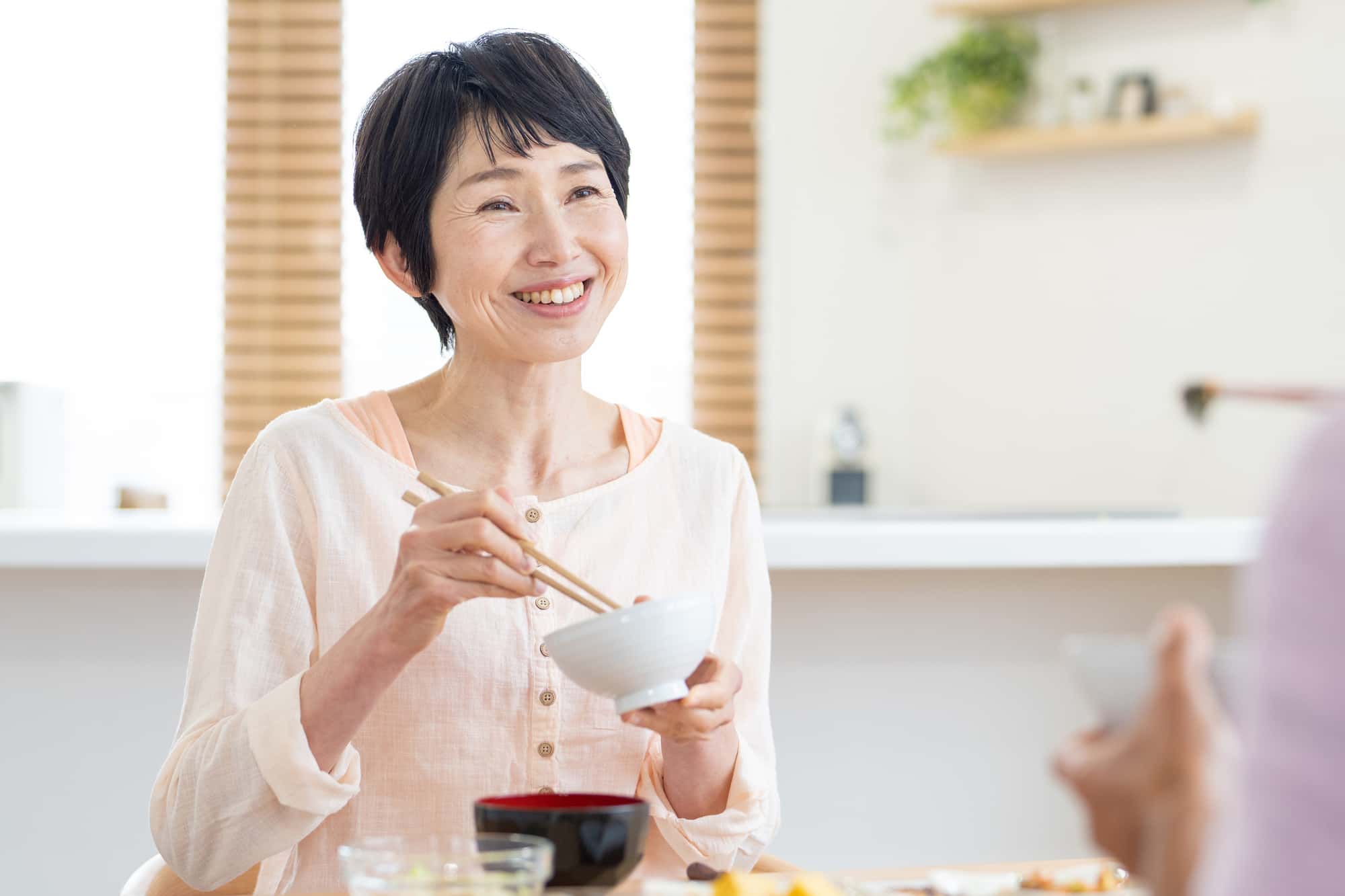 歯のブリッジ治療をして快適に食事を楽しむ女性