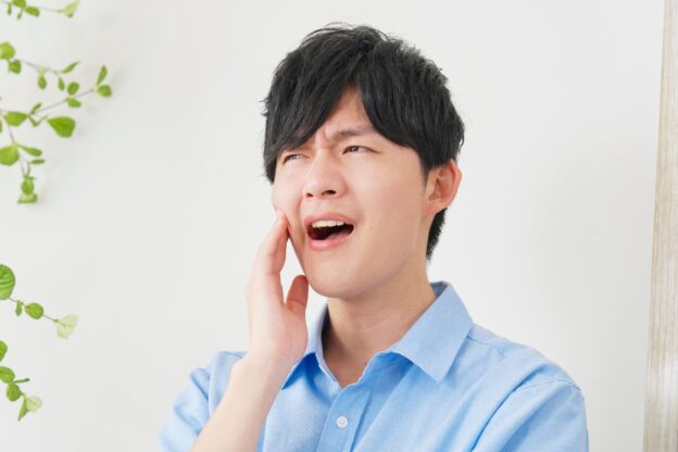 むし歯の治療後に痛みが出ている男性