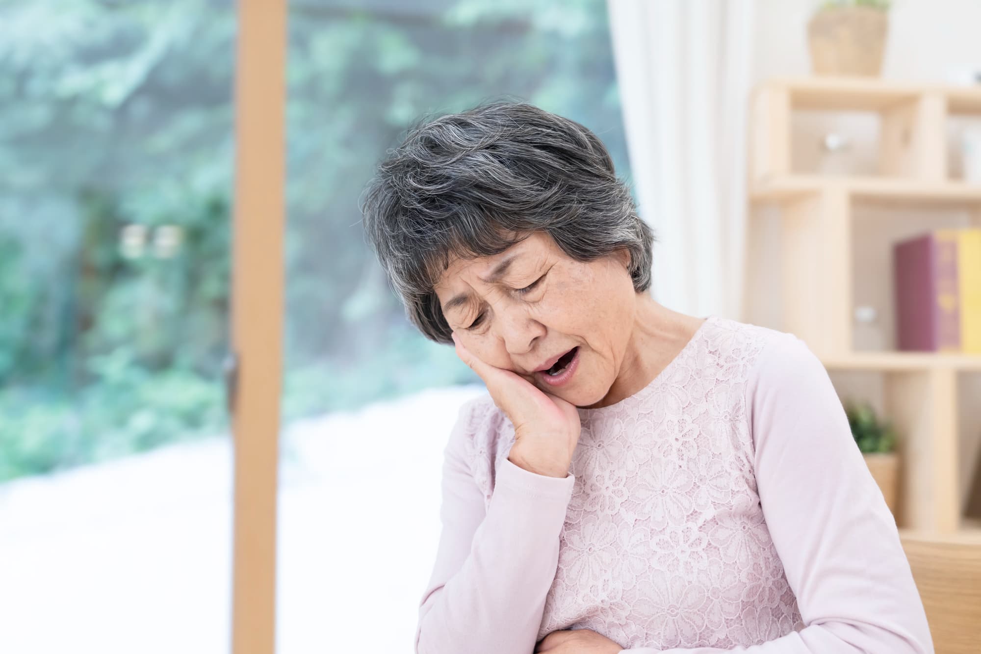 入れ歯が合わず痛みを感じる高齢女性