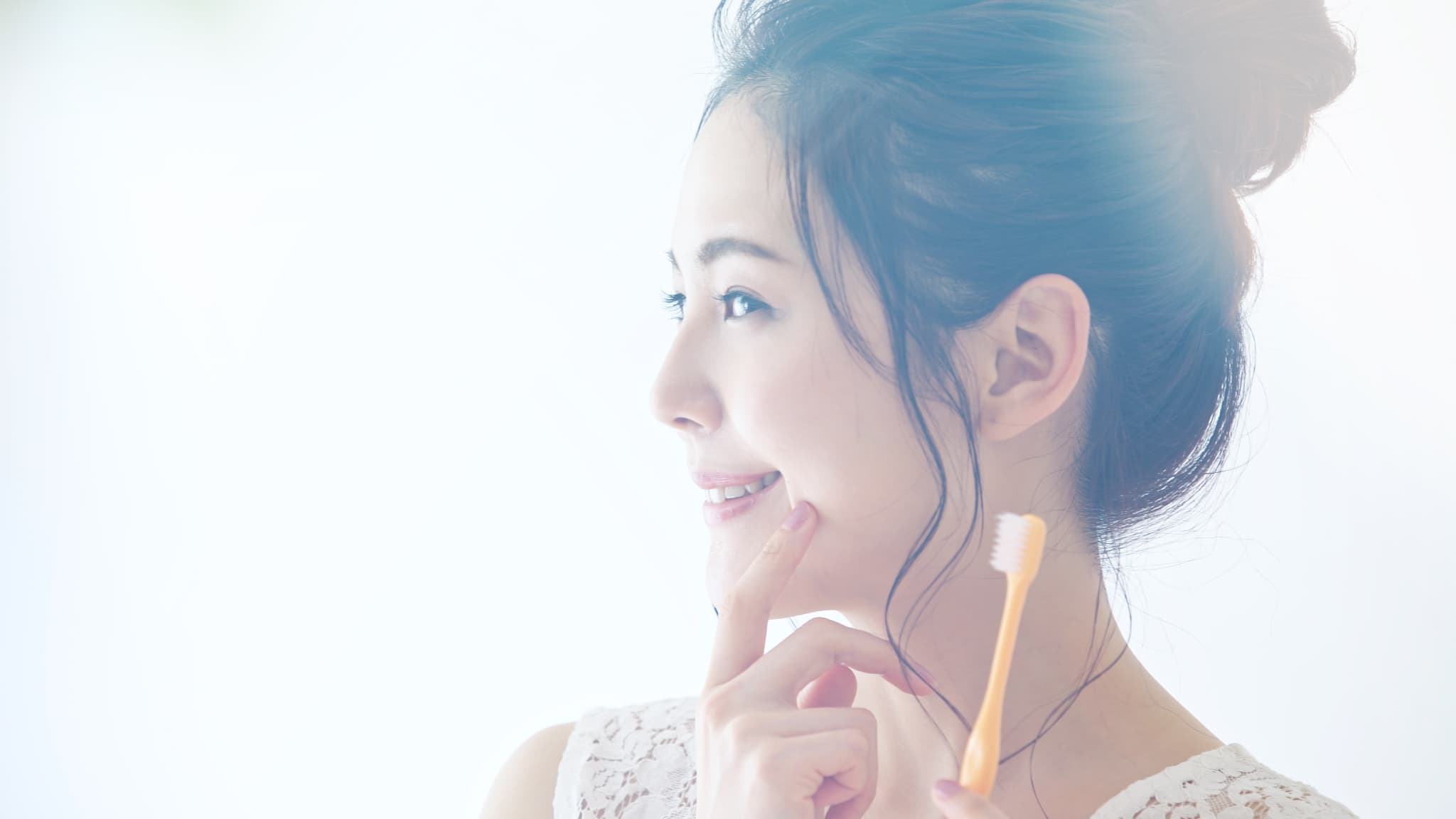 前歯の裏が虫歯になるのを防ぐため丁寧に歯磨きをする女性
