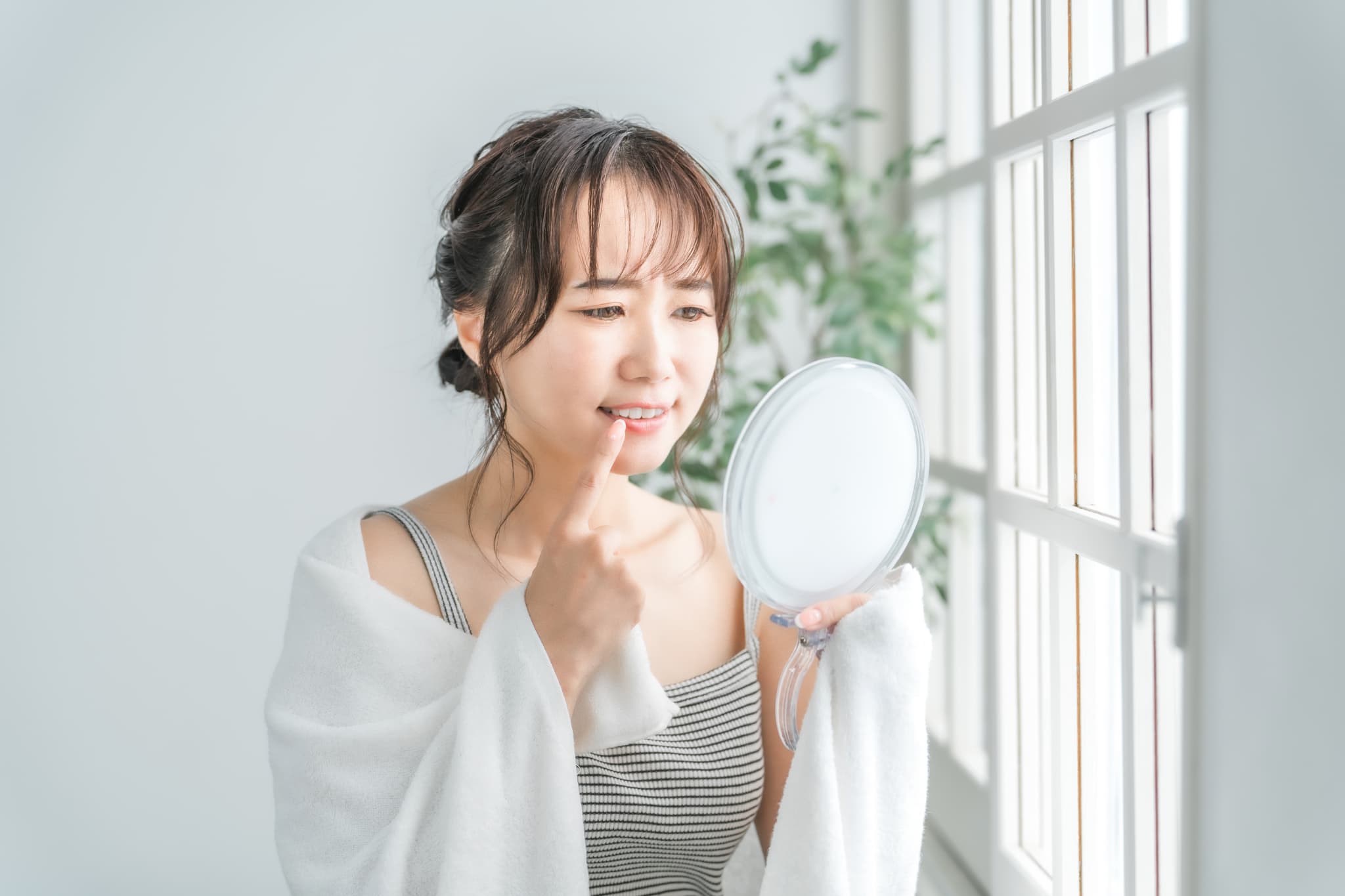 前歯の裏に虫歯がないか確認している女性