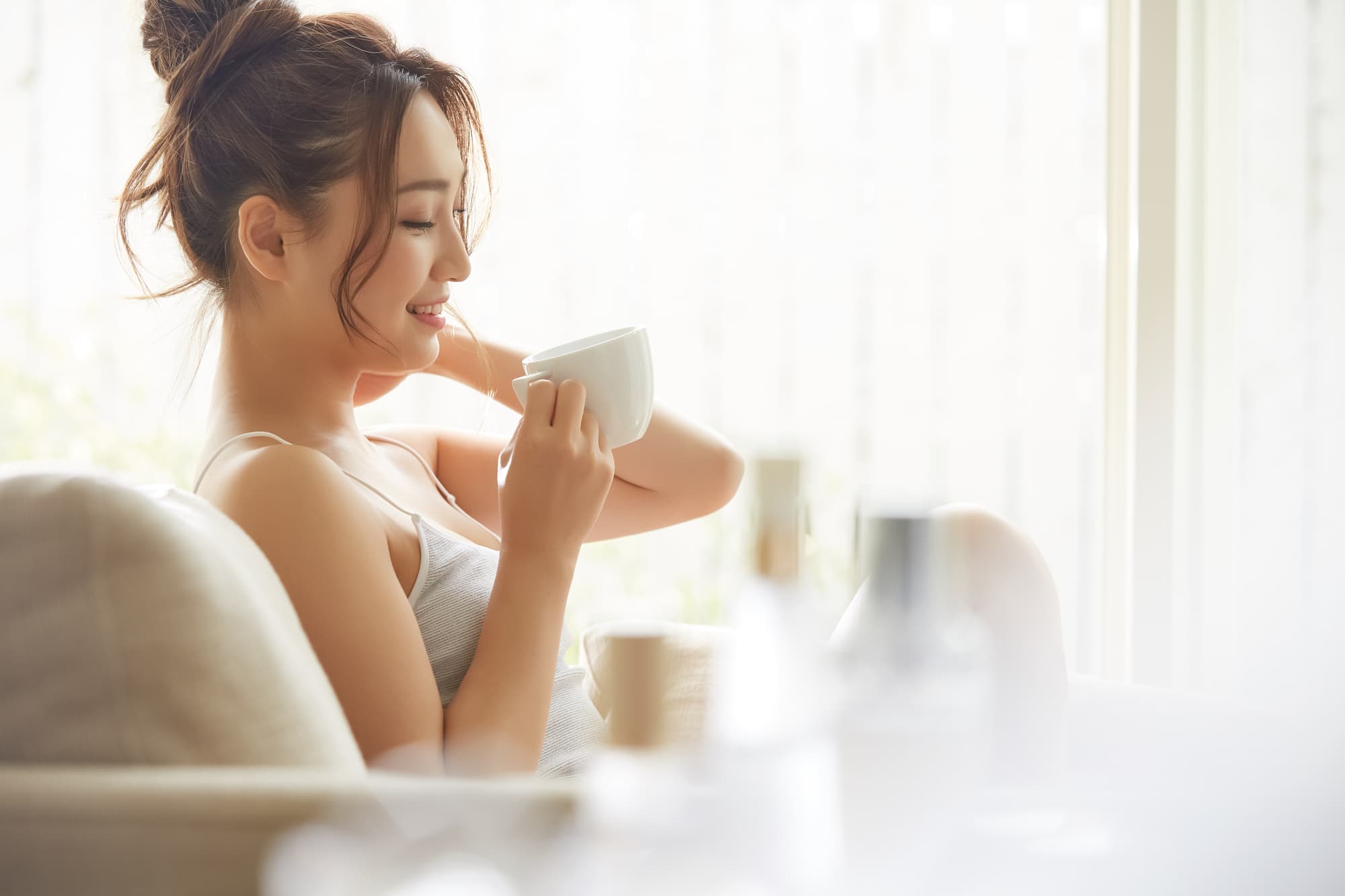 部屋でマグカップ片手にリラックスする女性
