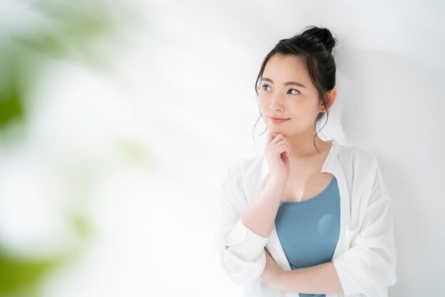 銀歯を白くしたいときはどうしたらいいか考える女性