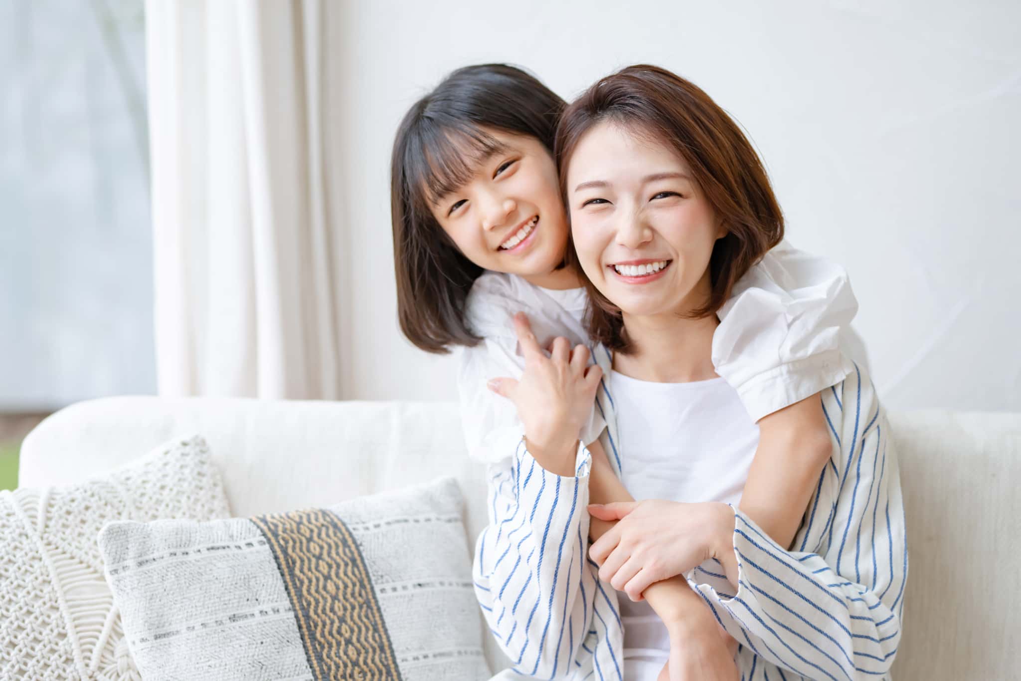 小児矯正をした綺麗な歯並びの子どもと笑顔の母親