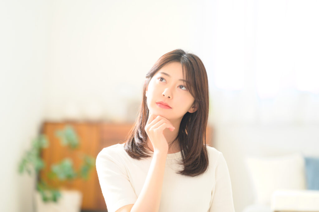 矯正治療後に起こる後戻りとは何かについて考えている女性