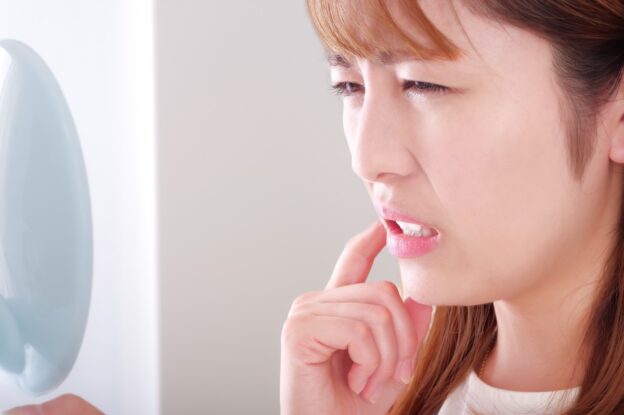 セラミック治療後にしみる女性