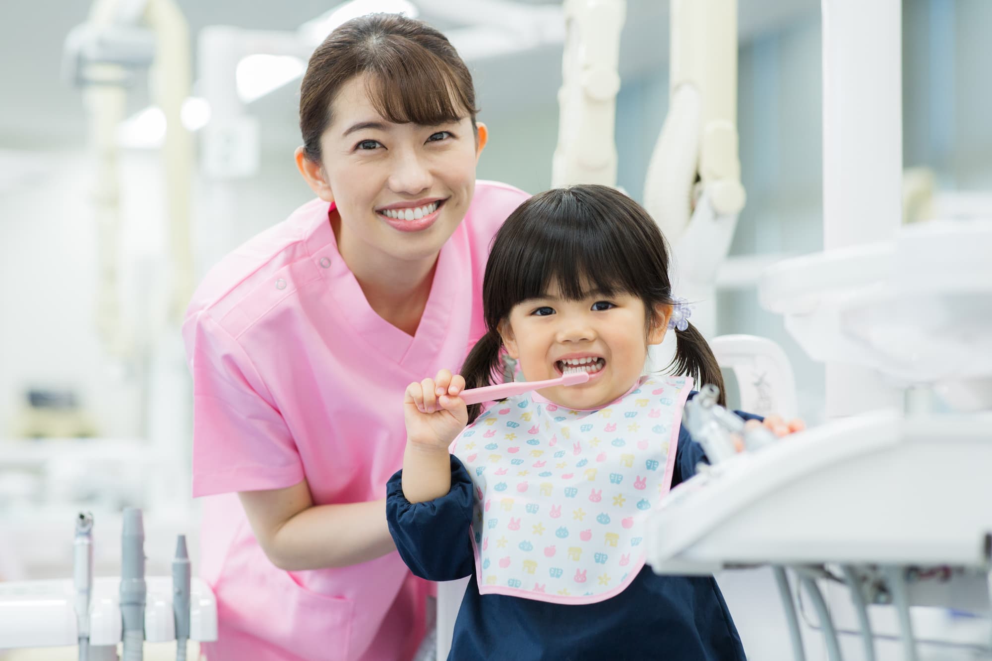 歯科衛生士からブラッシング指導を受けている子ども